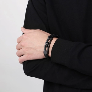 Close-up of double-row black braided leather bracelet with matte black metal clasp