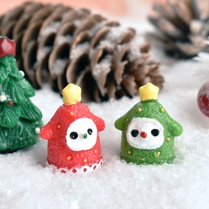 Close-up of resin Christmas tree snowman figurines in miniature snowy holiday scene