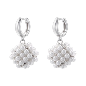 Detailed view of silver hoop earrings featuring white pearl cube-shaped drop pendants