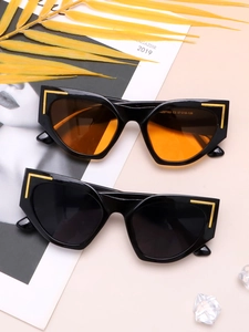 Detail showing oversized cat eye sunglasses with gold accents on a magazine background