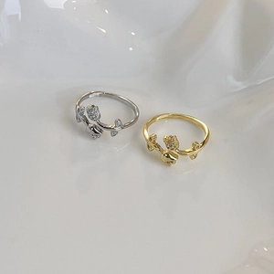 Detailed view of gold and silver tulip rings with micro-pave crystals on wavy tray