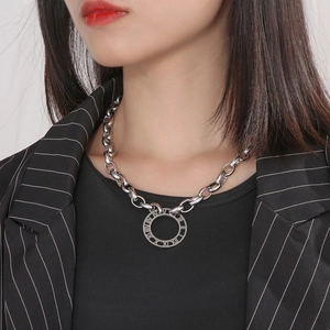 Detail of silver titanium thick chain necklace with Roman numeral ring pendant on a model