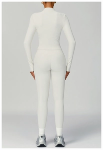 Detail view of white ribbed yoga set featuring a long sleeve top and high waist leggings