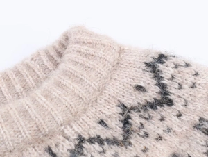 Detailed close-up of ribbed crewneck and jacquard knit texture on beige wool sweater