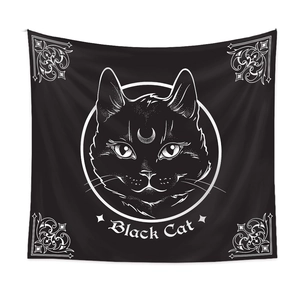 Detail of black tapestry featuring a white cat head and crescent moon pattern