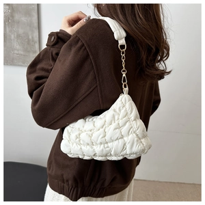 Détail du sac bandoulière blanc matelassé avec chaîne dorée et texture douce