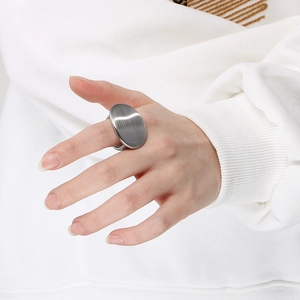 Macro view of a large oval stainless steel ring with brushed metal texture details