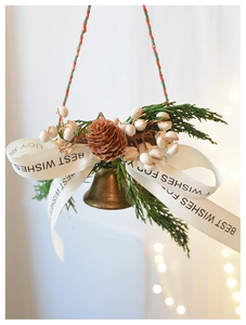Detail of pine cone Christmas hanging ornament with bronze bell and white berries