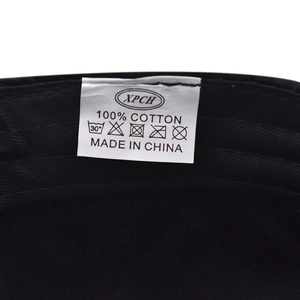 Detail view of the 100% cotton material tag and interior stitching on the black cap