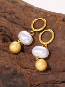 Close-up of 18k gold plated tassel earring with faux pearl and frosted metal ball detail