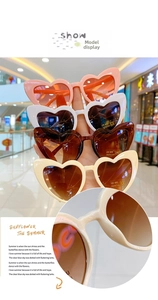 Detail showing UV400 protection logo and CE certification on heart-shaped sunglasses