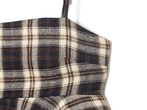 Detailed macro view of the blue and brown plaid fabric texture and thin strap stitching