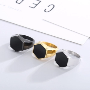 Detail of hexagonal signet rings for men in matte black, polished gold and silver steel