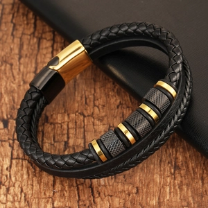 Close-up of black braided leather bracelet with gold spacers and magnetic clasp