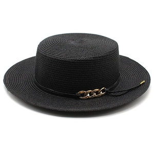 Détail d'un chapeau canotier noir avec texture tressée et chaîne dorée décorative