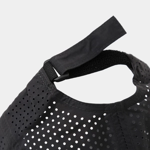 Macro view of adjustable velcro strap and breathable laser-cut holes on the black baseball cap