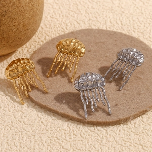 Détail macro de boucles d'oreilles méduse à texture martelée en finitions or et argent