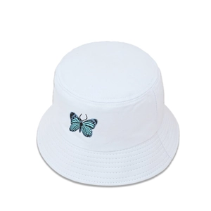 Détail de la broderie papillon bleue sur le chapeau bob en toile de coton blanc