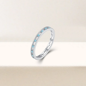 Detail of slim S925 silver ring featuring light blue zircon stones on a beige pedestal