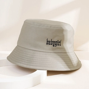 Dettaglio del ricamo babygirl su un cappello a secchiello in twill di cotone beige