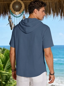 Rear view of man in breathable light blue linen short sleeve hoodie on a beach