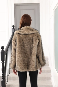Rear view of brown faux fur coat with belt and thick texture on white stairs