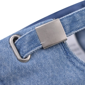 Makro-Detailansicht der gewaschenen hellblauen Jeans-Baseballkappe mit verstellbarer Silberschnalle