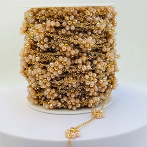 Dettaglio catena placcata oro con perline di cristallo sfaccettate champagne su rocchetto