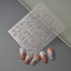 Gold-stamped floral nail stickers with red rhinestones and gradient manicure display