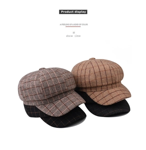Close-up of vintage plaid newsboy caps in gray and camel wool blend fabric textures