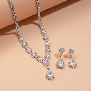 Detail of luxury teardrop zircon necklace and earrings set with polished silver finish
