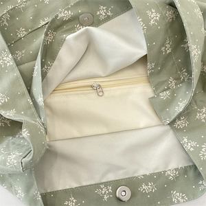 Détail du sac cabas en toile fleurie avec boucle magnétique et poche intérieure zippée
