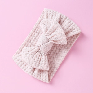 Detail of soft waffle knit texture and large bow on pink infant headband