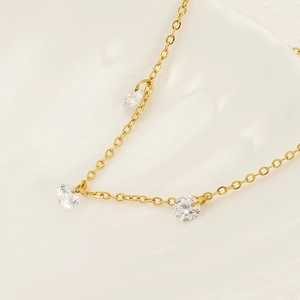 Elegant gold necklace with three sparkling round cubic zirconia stones on thin chain