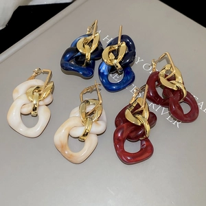 Close-up of vintage geometric acrylic chain earrings in blue, cream and dark red