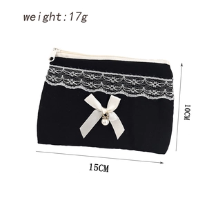 Detail of black velvet coin purse showing lace trim, bow with pearl and 15x10cm size