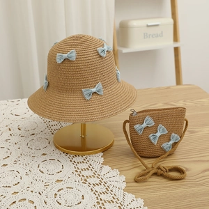 Detail of children's straw hat and matching bag set with sweet light blue lace bows