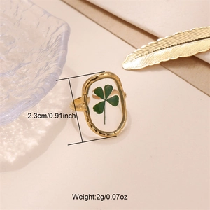 Detail of open gold ring with real four-leaf clover flower in resin and size specs