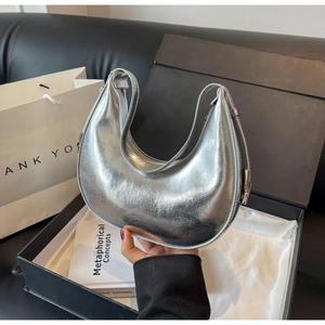 Detail of silver crescent shoulder bag with metallic finish in a stylish gift set display