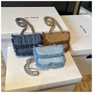 Detailed view of mini crossbody bags with frayed edges and metal chain straps in three colors