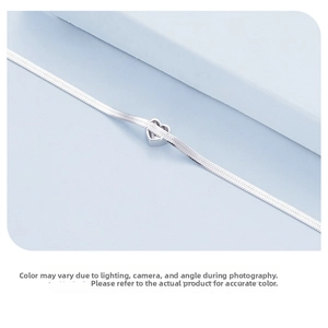 Macro shot of silver S925 sterling silver herringbone chain with heart charm pendant