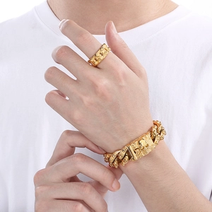 Close-up of golden stainless steel skull ring and bracelet set worn by male model