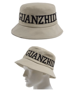 Gros plan d'un bob en coton beige avec broderie 3D noire sur fond blanc pur