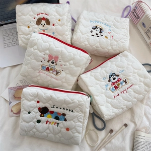 Detailed view of white quilted heart patterns and cute cartoon puppy embroidery on bags