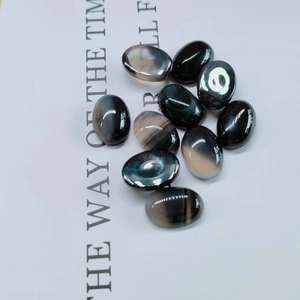 Macro detail of polished oval black agate stone cabochon with natural grey veins