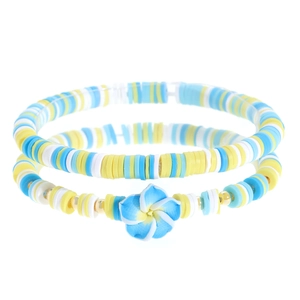 Dettaglio di braccialetti boho con perline Heishi colorate e decorazione a fiore di plumeria