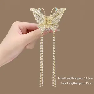 Detail of golden butterfly hair claw with tassel pendant and rhinestone inlay, 15cm length