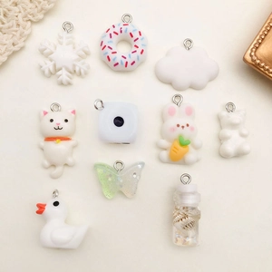 Macro shot of 10 colorful DIY resin charms including donuts, animals, and snowflakes