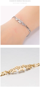 Dettaglio di eleganti braccialetti con ciondoli a farfalla traforati in oro e argento