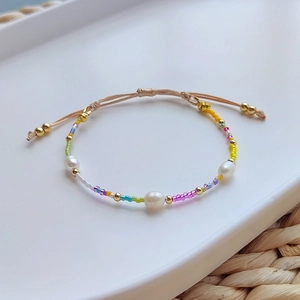Detail of bohemian handmade beaded bracelet with freshwater pearls and adjustable cord